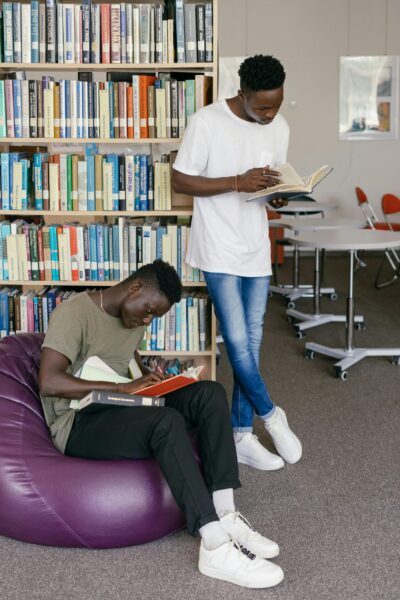 Two young men studying in a library, emphasizing education and learning.